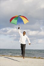 African man running with beach umbrella