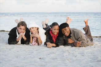 Multi-ethnic couples laying on beach