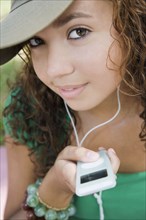Hispanic teenaged girl holding mp3 player