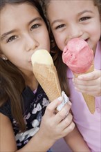 Hispanic sisters eating ice cream cones