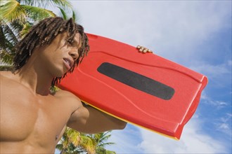 African man carrying lifeguard float