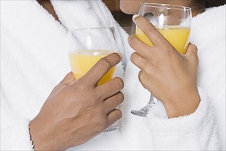 African couple holding orange juice