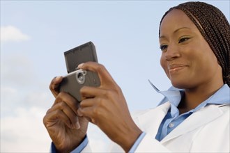 African businesswoman looking at cell phone