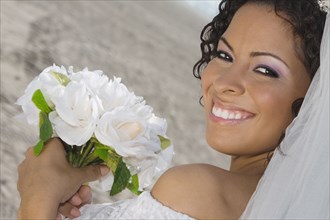 Hispanic bride holding bouquet