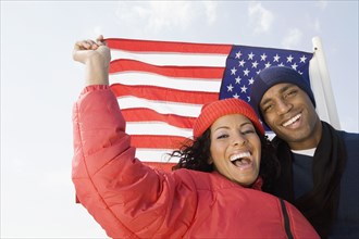 Multi-ethnic couple in front of American flag