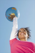 Hispanic woman holding globe ball