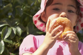 Hispanic baby girl eating doughnut