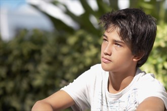Pacific Islander boy sitting outdoors