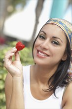 Hispanic woman eating strawberry