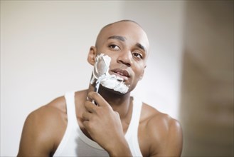 African man shaving face