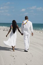 African couple holding hands at beach