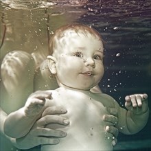 Caucasian baby being held underwater