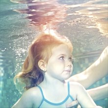 Caucasian girl swimming under water