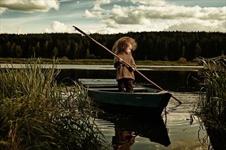 Caucasian girl rowing canoe in still lake