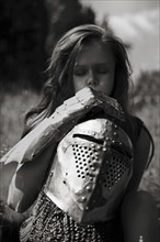 Caucasian girl carrying armor outdoors