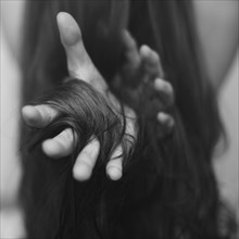 Hair wrapped around Caucasian woman's hand
