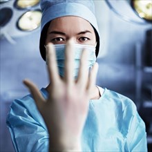 Caucasian surgeon pulling on glove in operating room
