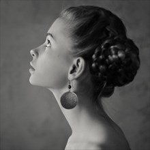 Teenage girl with braided hair wearing dangling earrings