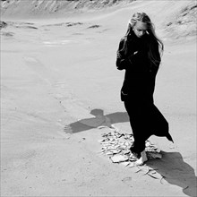 Caucasian teenage girl standing on beach near shadow of eagle