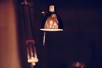 Close up of illuminated desk lamp at night