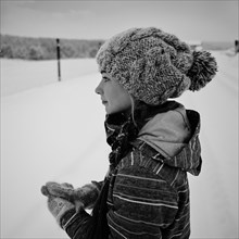 Caucasian girl wearing knit cap and gloves in snow