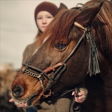 Caucasian girl holding rein of horse