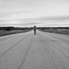 Caucasian girl standing on empty rural road