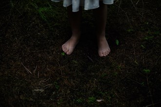 Caucasian girl with bare feet in dirt