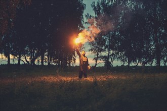 Caucasian man holding torch in field
