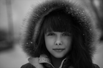 Caucasian girl wearing fur hood in snow