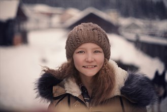 Caucasian girl wearing beanie hat and coat in snow
