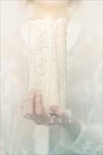 Caucasian woman holding melting candle
