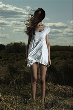 Caucasian woman standing in windy field