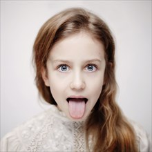Caucasian teenage girl sticking out tongue