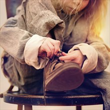 Caucasian girl tying her shoe