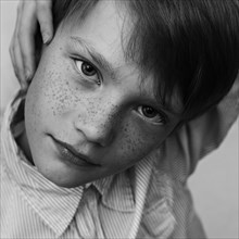 Close up of serious Caucasian boy with freckles