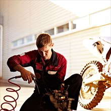 Caucasian mechanic examining motorcycle parts