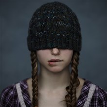 Caucasian girl wearing beanie hat over eyes