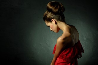 Caucasian woman wearing red evening gown and hair bun
