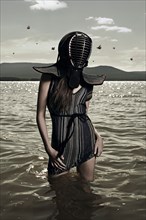 Caucasian woman wearing mask in lake