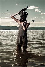 Caucasian woman wearing mask in lake