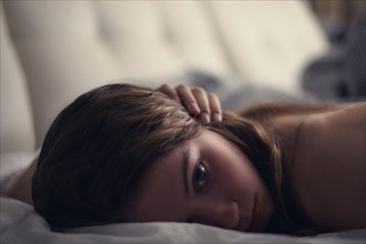 Caucasian teenage girl laying on bed