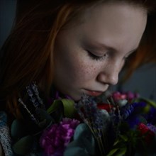 Caucasian teenage girl smelling flowers