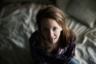 Caucasian teenage girl sticking out tongue