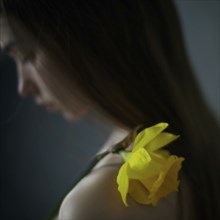Caucasian girl with yellow flower on shoulder
