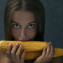Caucasian girl eating corn on cob