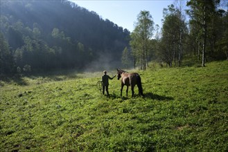 Caucasian girl walking horse in field