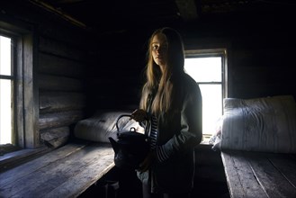 Caucasian girl holding kettle in log home