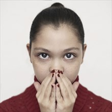 Caucasian girl covering mouth with hands