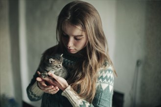 Caucasian woman holding kitten